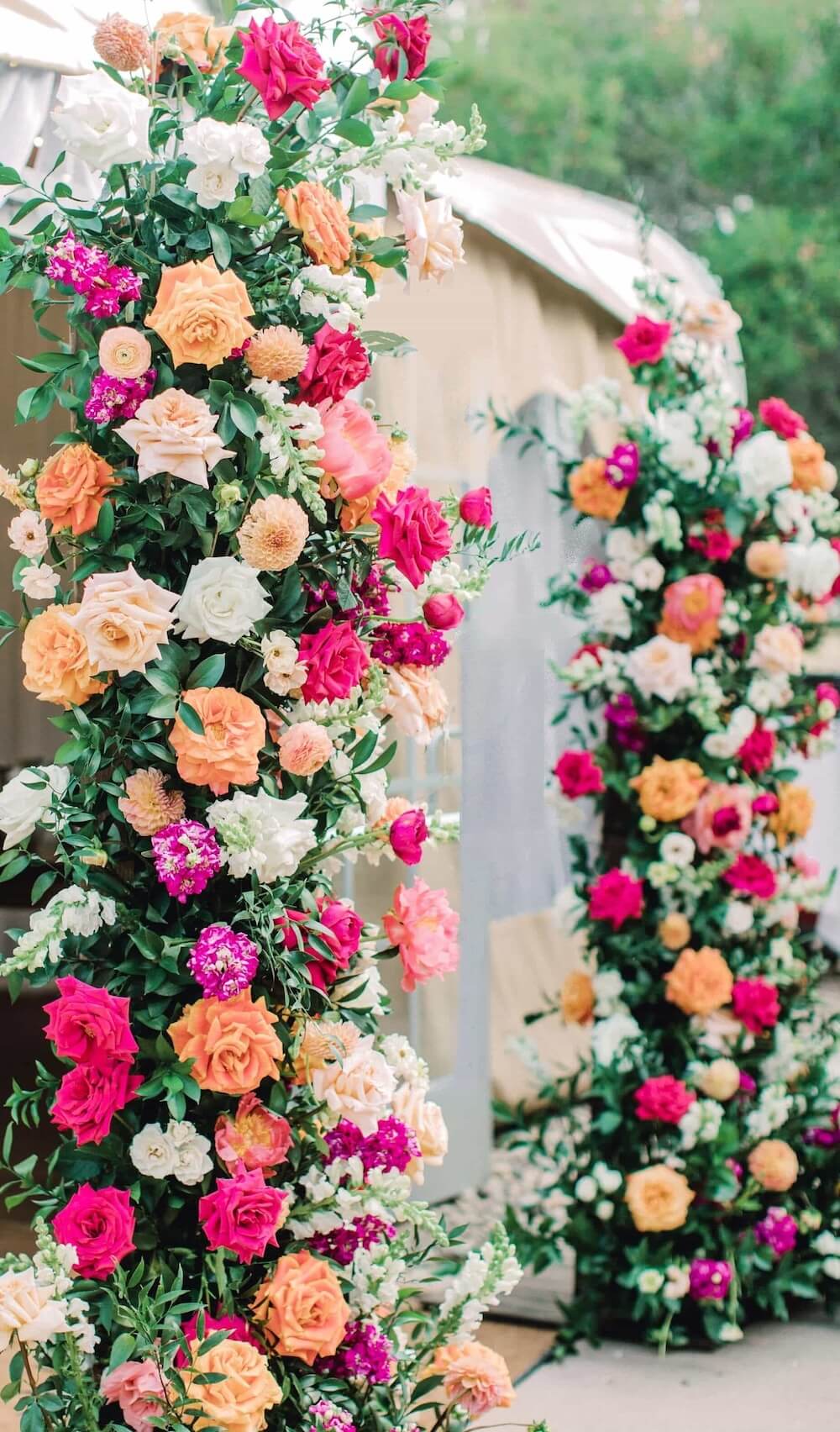 floral arch at san diego wedding ceremony with hot pink and orange fun vibrant flowers